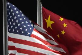 Las banderas de Estados Unidos (izquierda) y China ondean juntas antes de una competición de los Juegos Olímpicos de Invierno de 2022, el 2 de febrero de 2022, en Zhangjiakou, China. FOTO: