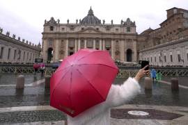 Una mujer toma fotos bajo la lluvia en la plaza de San Pedro en el Vaticano, el sábado 1 de marzo de 2025. FOTO: