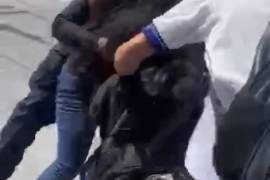 El momento en que las dos alumnas de la Secundaria Federal Número 5 Harold R. Pape se enfrentan a golpes en la Zona Centro de Monclova, mientras un policía municipal intenta intervenir.