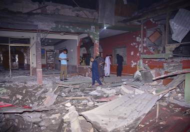 Habitantes y miembros de la prensa examinan un edificio dañado por un presunto ataque de India con misiles cerca de Muzaffarabad, la capital de la Cachemira controlada por Pakistán, el miércoles 7 de mayo de 2025.