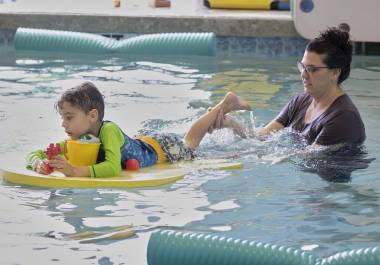 La terapeuta ocupacional Angelina Price, de The Learning Center, guía a un estudiante en el agua durante una clase de natación específica para autismo en Small Fish Big Fish, en West Palm Beach, Florida.